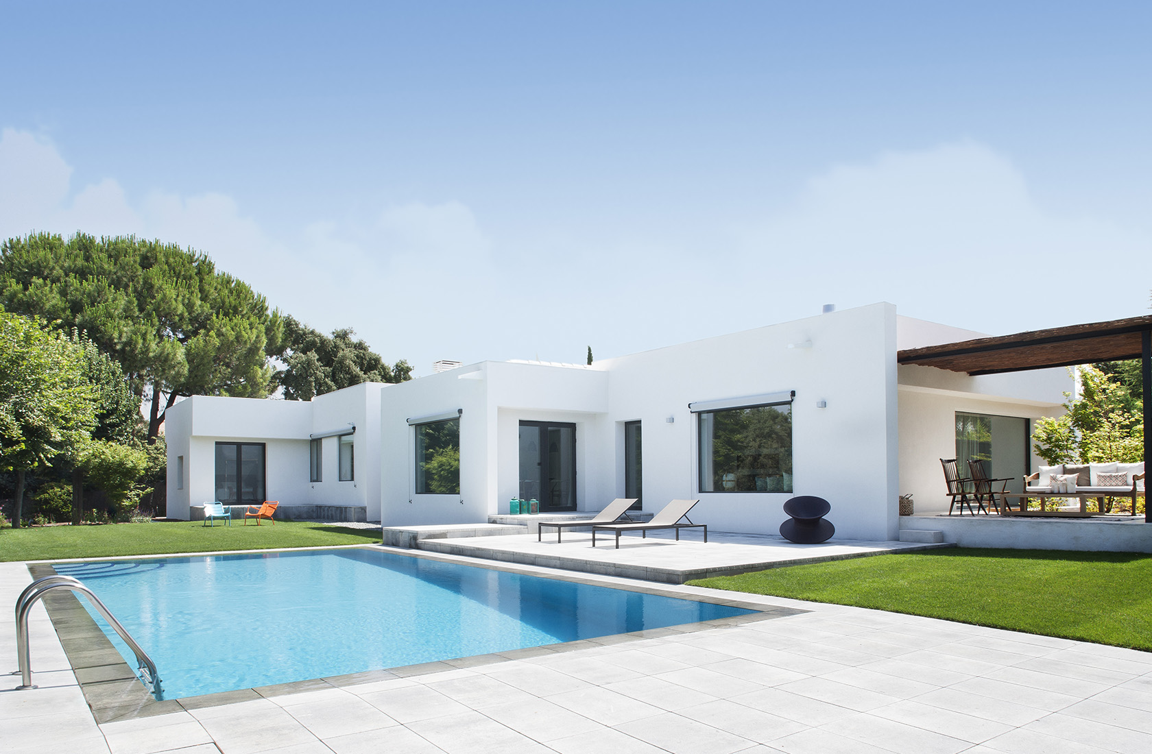 Vista general del piscina y fachada trasera de la reforma integral vivienda en La Moraleja